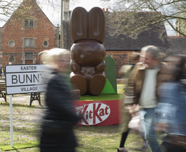 people walking past the giant chocolate bunny