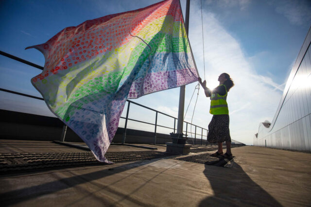 someone raising the rainbow flag