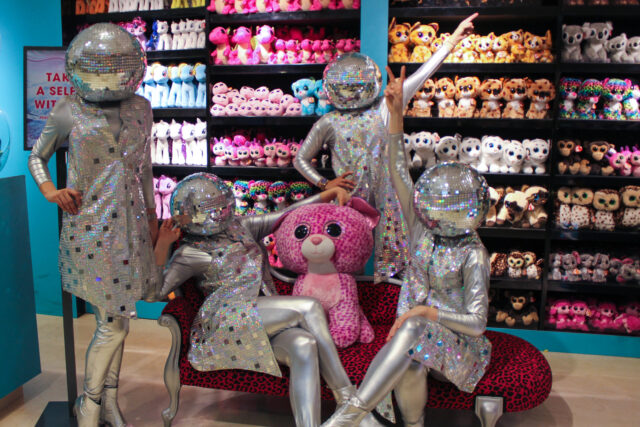 people dressed as disco balls in a toy shop