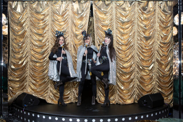Singers in front a gold curtsin